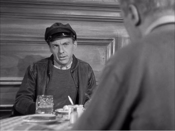 Movie still from “Portrait of Jennie” (1948), directed by William Dieterle – A black and white photo of a man sitting at a table; Medium shot, Over the shoulder angle