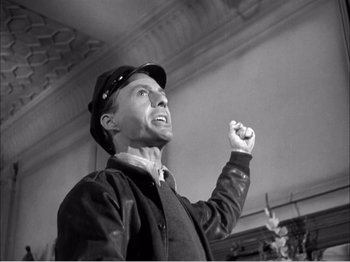 Movie still from “Portrait of Jennie” (1948), directed by William Dieterle – A man in a hat and jacket raising his fist; Close Up shot, Low angle