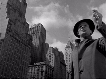Movie still from “Portrait of Jennie” (1948), directed by William Dieterle – A black and white photo of a man in a hat and coat; Wide shot, Low angle