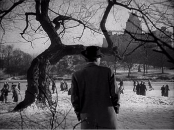 Movie still from “Portrait of Jennie” (1948), directed by William Dieterle – A man standing in front of a group of people in a park; Wide shot, Low angle