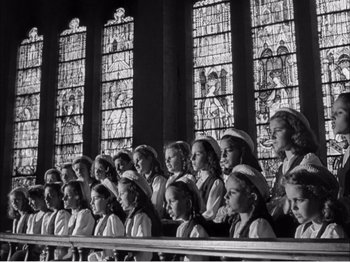 Movie still from “Portrait of Jennie” (1948), directed by William Dieterle – A black and white photo of a group of young girls in front of stained glass windows; Medium shot, Low angle