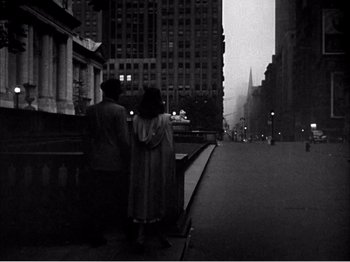 Movie still from “Portrait of Jennie” (1948), directed by William Dieterle – Two people standing on the side of the street; Wide shot, High angle