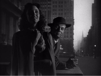 Movie still from “Portrait of Jennie” (1948), directed by William Dieterle – A man and a woman standing next to each other on the street; Medium shot, Low angle