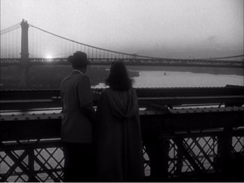 Movie still from “Portrait of Jennie” (1948), directed by William Dieterle – A man and a woman looking out over a bridge; Wide shot, High angle