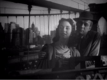 Movie still from “Portrait of Jennie” (1948), directed by William Dieterle – A man and a woman standing next to each other on a bridge; Medium shot, Low angle