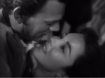 Movie still from “Portrait of Jennie” (1948), directed by William Dieterle – A black and white photo of a man and a woman kissing; Close Up shot, High angle