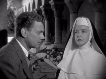 Movie still from “Portrait of Jennie” (1948), directed by William Dieterle – A man and a woman standing next to each other in front of an archway; Medium shot, High angle
