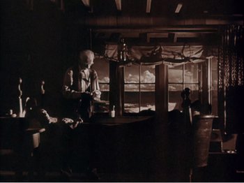 Movie still from “Portrait of Jennie” (1948), directed by William Dieterle – A group of people sitting at a table in front of a window; Wide shot, Low angle