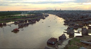 Movie still from “Powaqqatsi” (1988), directed by Godfrey Reggio – An aerial view of a body of water with houses on it; Extreme Wide shot, High angle