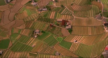 Movie still from “Powaqqatsi” (1988), directed by Godfrey Reggio – An aerial view of a field with many different types of crops; Extreme Wide shot, Overhead angle