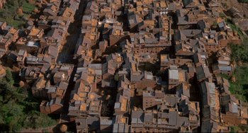 Movie still from “Powaqqatsi” (1988), directed by Godfrey Reggio – An aerial view of an urban area with lots of buildings; Extreme Wide shot, Overhead angle