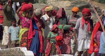 Movie still from “Powaqqatsi” (1988), directed by Godfrey Reggio – A group of people standing next to each other on a beach; Wide shot, High angle