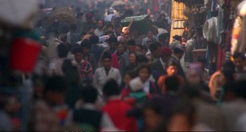 Movie still from “Powaqqatsi” (1988), directed by Godfrey Reggio – A large group of people walking down a street; Extreme Wide shot, High angle