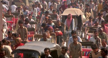 Movie still from “Powaqqatsi” (1988), directed by Godfrey Reggio – A large group of people walking down a street; Extreme Wide shot, High angle