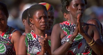 Movie still from “Powaqqatsi” (1988), directed by Godfrey Reggio – A group of women standing next to each other clapping; Close Up shot, High angle