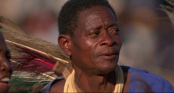 Movie still from “Powaqqatsi” (1988), directed by Godfrey Reggio – An older man is holding a broom in his hand; Close Up shot, Low angle