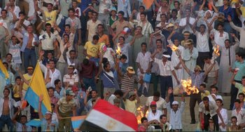 Movie still from “Powaqqatsi” (1988), directed by Godfrey Reggio – A group of people standing in a crowd holding torches; Extreme Wide shot, High angle