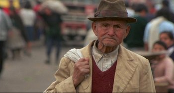 Movie still from “Powaqqatsi” (1988), directed by Godfrey Reggio – An old man wearing a hat and holding a fan; Close Up shot, Low angle