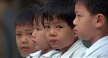 Movie still from “Powaqqatsi” (1988), directed by Godfrey Reggio – A group of young boys standing next to each other; Close Up shot, High angle