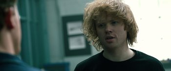 Movie still from “Power Rangers” (2017), directed by Dean Israelite – A man with blonde curly hair is looking at the camera; Close Up shot, Over the shoulder angle