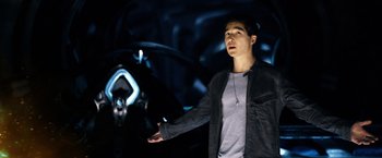 Movie still from “Power Rangers” (2017), directed by Dean Israelite – A man standing in front of a car in a dark room; Medium shot, Low angle
