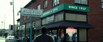 Movie still from “Power Rangers” (2017), directed by Dean Israelite – A man standing in front of a krispy kreme store; Wide shot, Over the shoulder angle