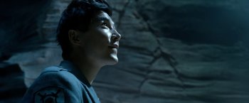 Movie still from “Power Rangers” (2017), directed by Dean Israelite – A man looking up at the sky in front of a rock wall; Close Up shot, Low angle