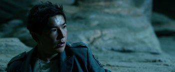Movie still from “Power Rangers” (2017), directed by Dean Israelite – A young man in a military uniform sitting on the ground; Close Up shot, High angle