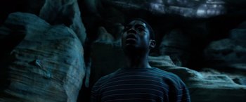 Movie still from “Power Rangers” (2017), directed by Dean Israelite – A man standing in front of a rock wall; Close Up shot, Low angle