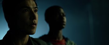 Movie still from “Power Rangers” (2017), directed by Dean Israelite – A man and a woman looking at something in the dark; Close Up shot, Low angle