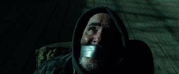 Movie still from “Power Rangers” (2017), directed by Dean Israelite – A man with his mouth taped shut is sitting down; Close Up shot, Low angle
