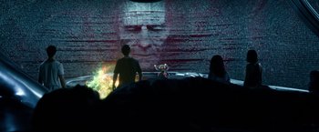 Movie still from “Power Rangers” (2017), directed by Dean Israelite – A man standing in front of a wall with a picture on it; Wide shot, Over the shoulder angle