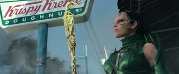 Movie still from “Power Rangers” (2017), directed by Dean Israelite – A woman dressed in green standing next to a pole; Medium shot, Low angle