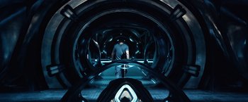 Movie still from “Power Rangers” (2017), directed by Dean Israelite – A man riding on the back of an escalator in a tunnel; Wide shot, High angle
