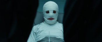 Movie still from “Predestination” (2014), directed by Michael Spierig – A person with a bandaged head sitting in a chair; Close Up shot, Over the shoulder angle