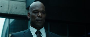 Movie still from “Predestination” (2014), directed by Michael Spierig – A man in a suit and tie looking at the camera; Close Up shot, Over the shoulder angle