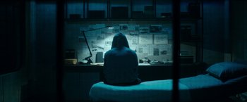 Movie still from “Predestination” (2014), directed by Michael Spierig – A person sitting in front of a computer monitor; Wide shot, High angle