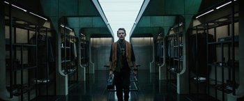 Movie still from “Predestination” (2014), directed by Michael Spierig – A man standing in front of a mirror in a building; Wide shot, Low angle