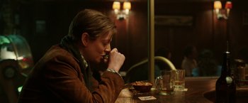 Movie still from “Predestination” (2014), directed by Michael Spierig – A man sitting at a table with a bowl of food; Medium shot, Over the shoulder angle