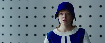 Movie still from “Predestination” (2014), directed by Michael Spierig – A woman wearing a blue hat and a white and blue dress; Close Up shot, Low angle