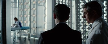 Movie still from “Predestination” (2014), directed by Michael Spierig – A man in a suit looking out of a window; Medium shot, Low angle