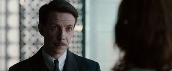 Movie still from “Predestination” (2014), directed by Michael Spierig – A person wearing a suit and tie; Close Up shot, Over the shoulder angle