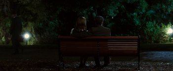 Movie still from “Predestination” (2014), directed by Michael Spierig – A man and a woman sitting on top of a wooden bench; Wide shot, High angle