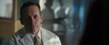 Movie still from “Predestination” (2014), directed by Michael Spierig – A person wearing a lab coat; Close Up shot, Over the shoulder angle