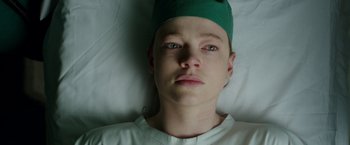 Movie still from “Predestination” (2014), directed by Michael Spierig – A person wearing a hat laying in a bed; Close Up shot, High angle