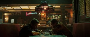 Movie still from “Predestination” (2014), directed by Michael Spierig – A couple of men sitting at a table in a bar; Medium shot, Over the shoulder angle
