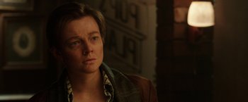 Movie still from “Predestination” (2014), directed by Michael Spierig – A woman with short brown hair wearing a brown jacket; Close Up shot, Over the shoulder angle