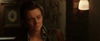 Movie still from “Predestination” (2014), directed by Michael Spierig – A woman with short hair is looking at the camera; Close Up shot, Over the shoulder angle