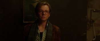 Movie still from “Predestination” (2014), directed by Michael Spierig – A person wearing glasses and a jacket; Close Up shot, Over the shoulder angle