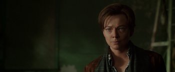 Movie still from “Predestination” (2014), directed by Michael Spierig – A woman with short hair wearing a brown jacket; Close Up shot, Over the shoulder angle
